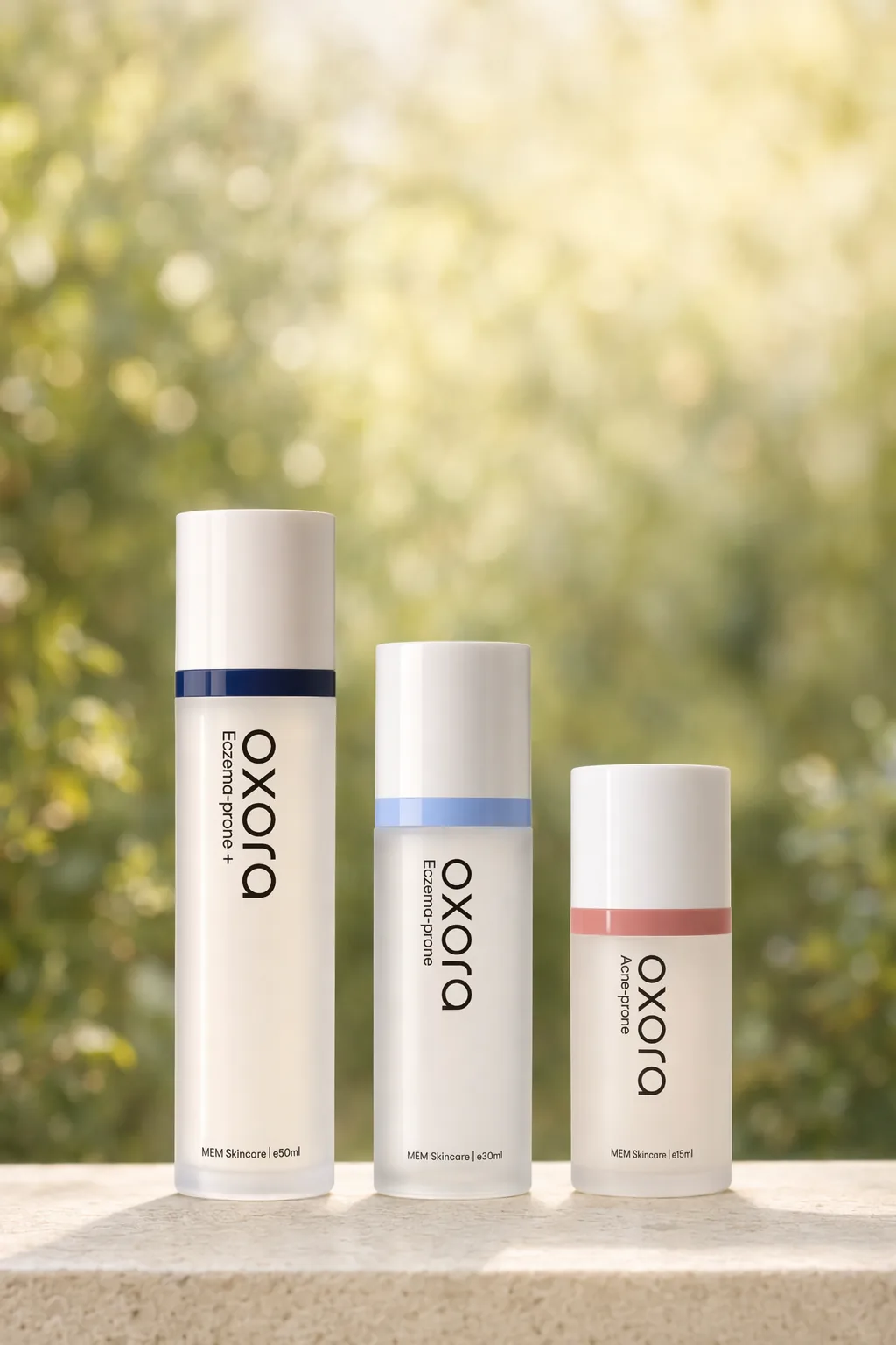 Oxora Acne-prone, EP, and EP Plus on a stone ledge, warm garden bokeh behind