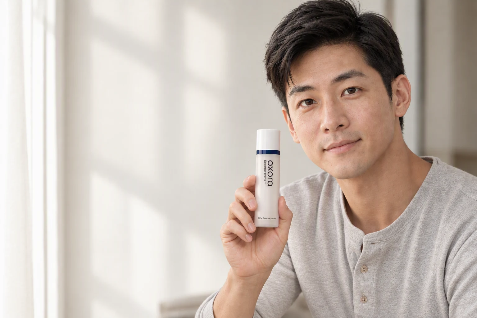 A man holding Oxora Eczema-prone Plus in soft window light